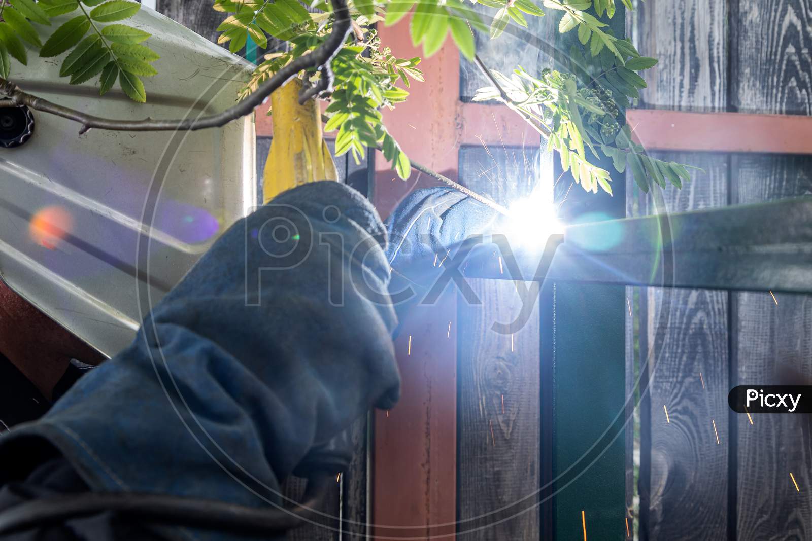 Image of Close Up Of A Young Man Welder In Uniform, Welding Mask And