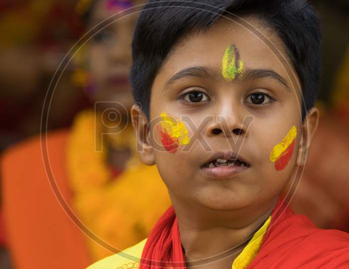Little boy in a colorful make-up and dress to celebrate Holi festival, also known as Basant utsav.