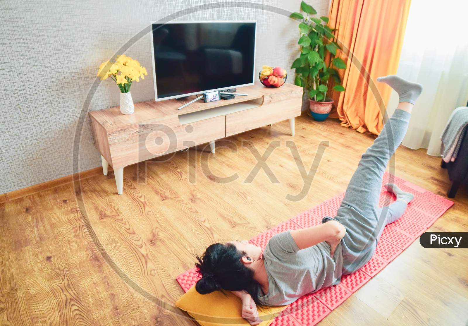 Woman Lay Ground On Side With Head On Pillow Lifting One Leg. Exercise Home Following Video Tutorial.