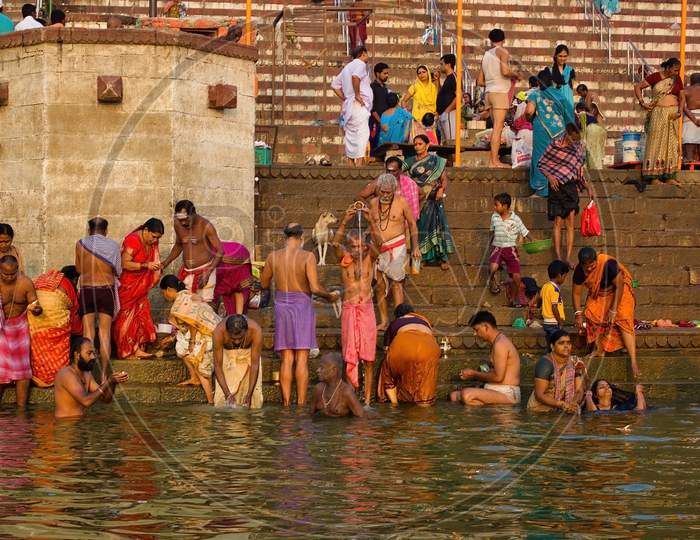 Varanasi, India - November 01, 2016: Bunch Of Hindu Pilgrims And Crowd Of People Participating In Holy Rituals And Prayers While Performing Dips In Ganges River In Banaras, Uttar Pradesh.