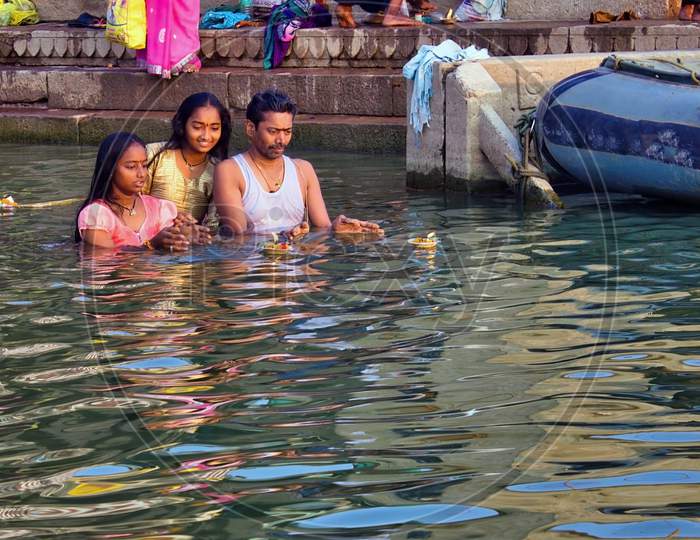 Varanasi, India - November 01, 2016: A Happy Family Of Father And Daughters Performing Prayer And Hindu Ritual In Holy Ganges River