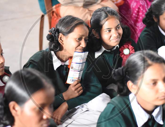Group of unidentified Indian girl students of government school inside the class room sitting on floor smiling and enjoying class activity
