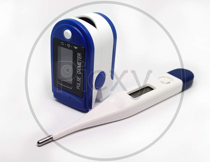 A Thermometer and a pulse oximeter isolated in white background