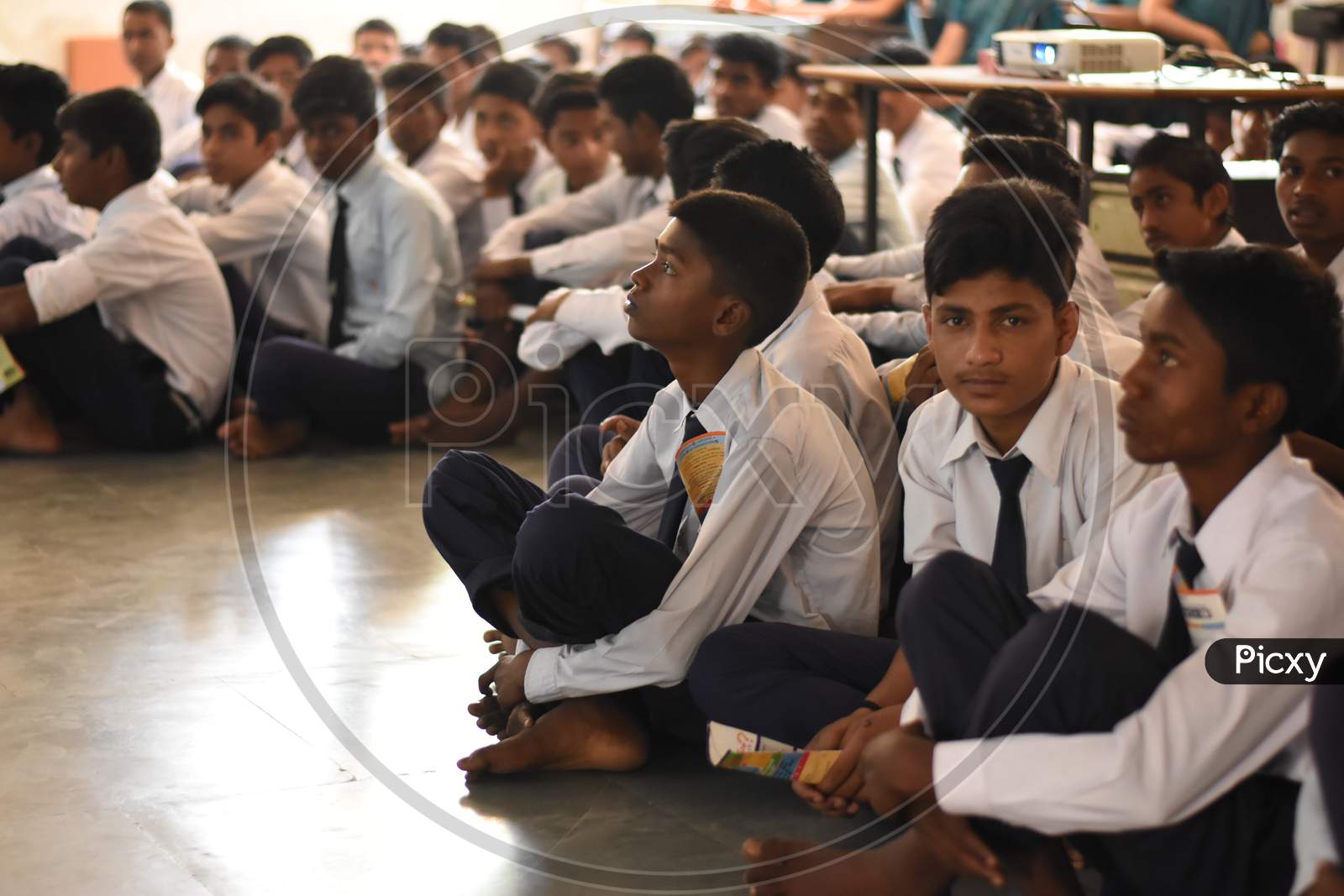 A group of unidentified  indian student  attending seminar in conference hall of school.