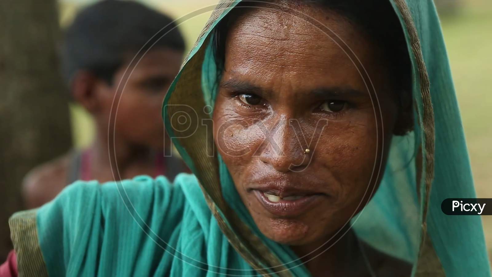 rural women of Indian ethnicity sitting portrait in the crowds. Blurry background image.