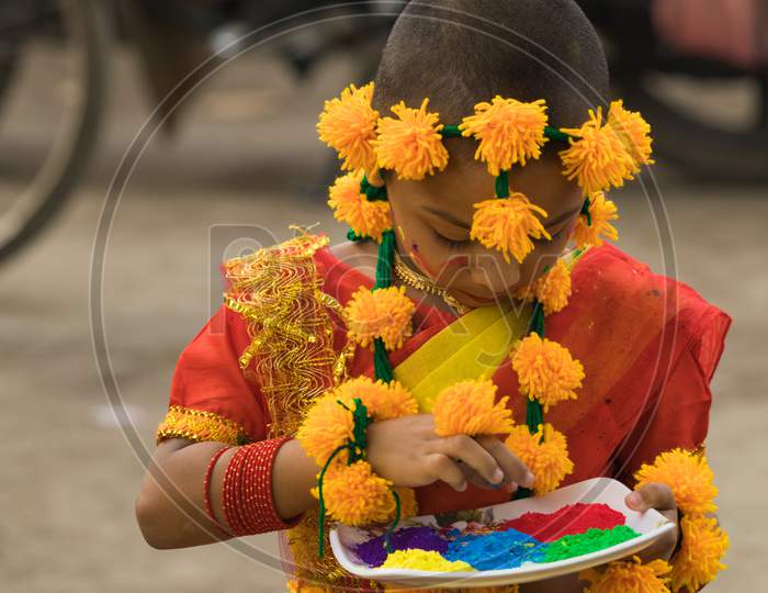 Little girl is playing with colors in the occasion of Holi festival.