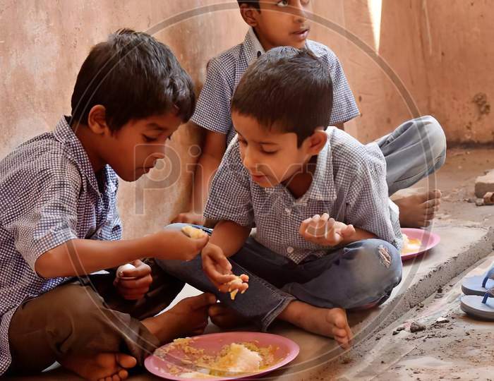 Indian school children eat their free midday meal at a government school