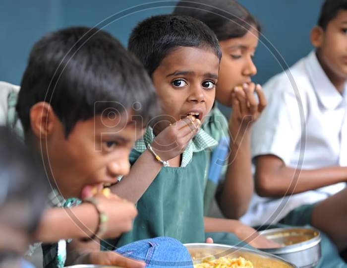 ndian school children sitting down and eating free mid day meal at a government school, Mid day meal