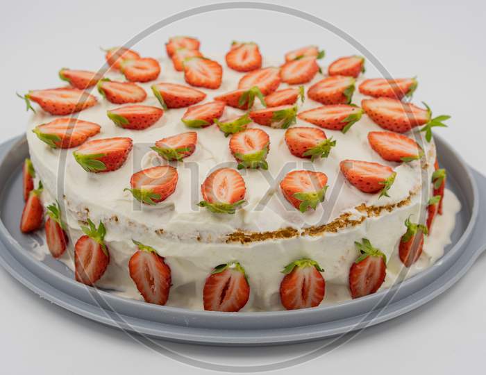 Isolated Strawberry Cheesecake On White Background Decorates With With Fresh Half Strawberries.