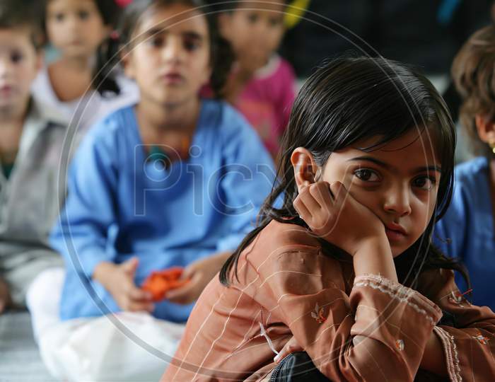 Closeup image of Cute girl child sitting in the floor of the school.