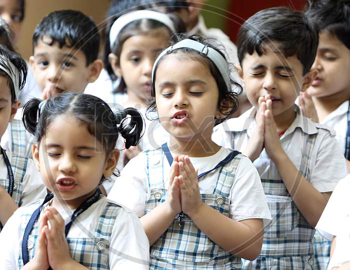 Unidentified school students praying together in the school Assembly.