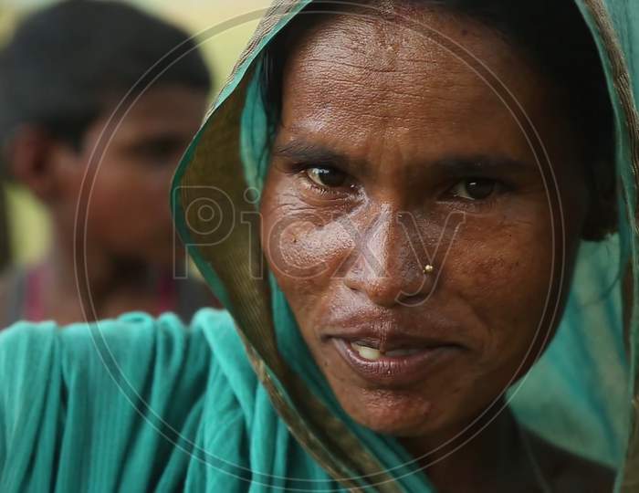 rural women of Indian ethnicity sitting portrait in the crowds. Blurry background image.