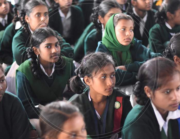 Group of unidentified Indian girl students of government school inside the class room sitting on floor smiling and enjoying class activity