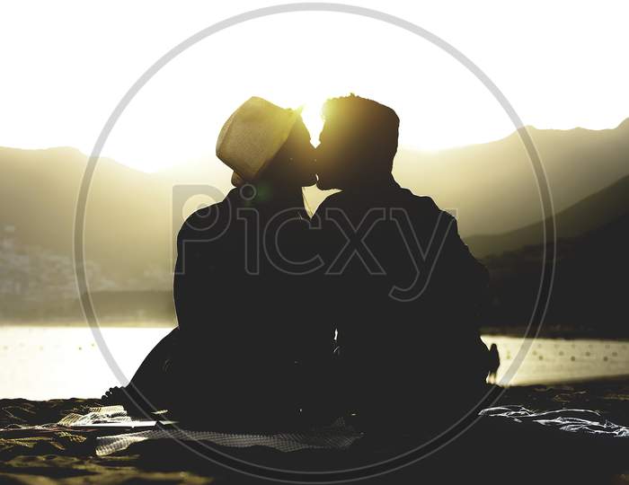close-up. On the beach  the ocean background a girl kissesf a man. High quality photo.