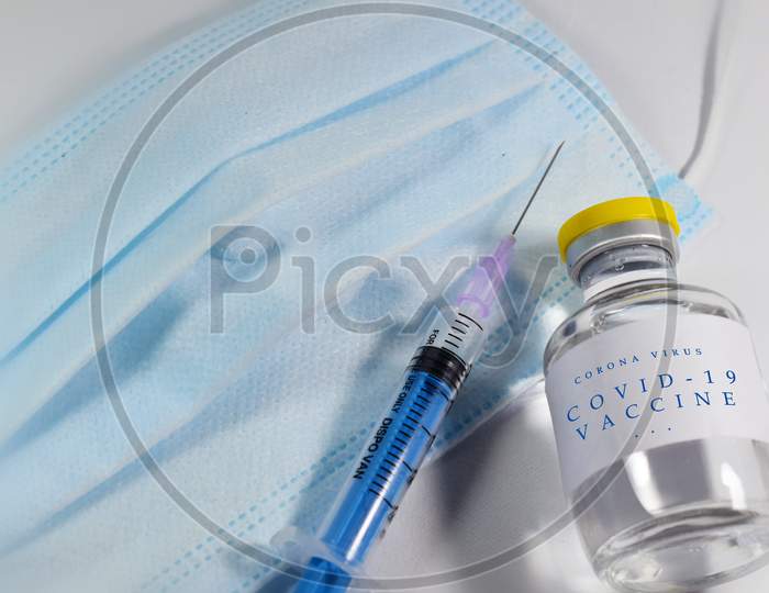 Covid 19 vaccine vial with syringe and mask