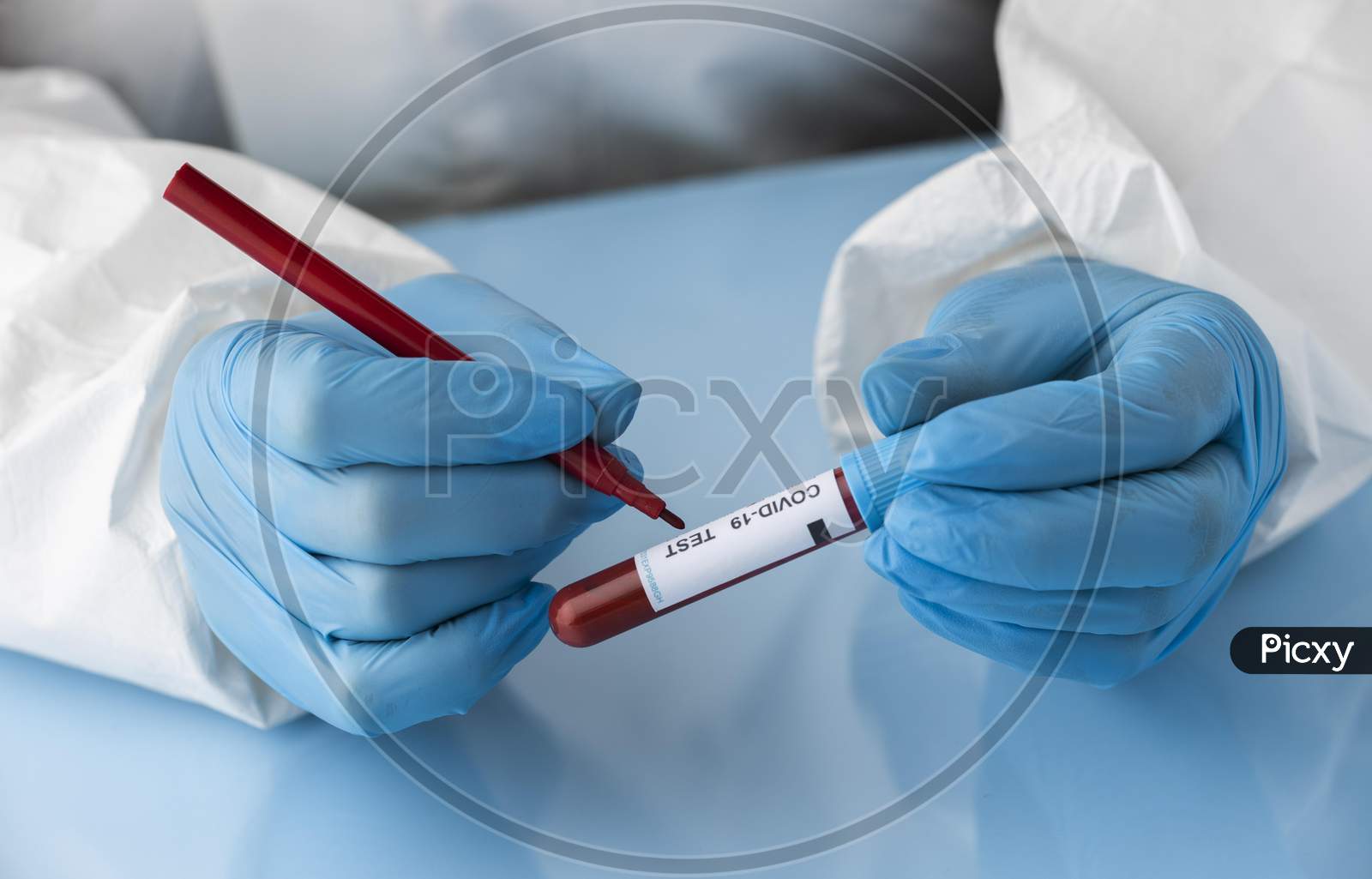 Hand with protective gloves holding a blood sample for covid