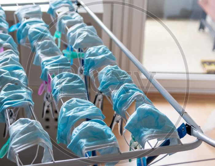 Image of Washed surgical masks hanging on a clothes drying rack after