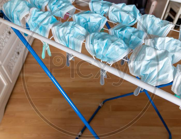 Image of Washed surgical masks hanging on a clothes drying rack after