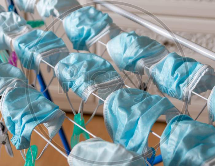 Image of Washed surgical masks hanging on a clothes drying rack after