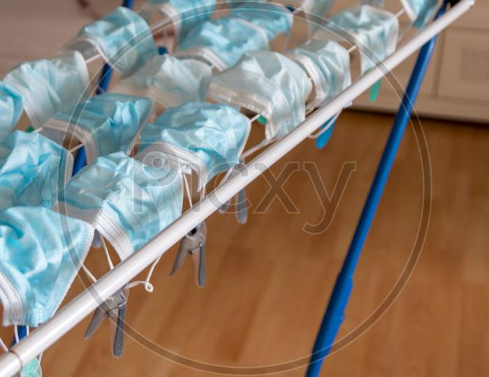 Image of Washed surgical masks hanging on a clothes drying rack after