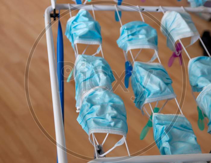 Image of Washed surgical masks hanging on a clothes drying rack after