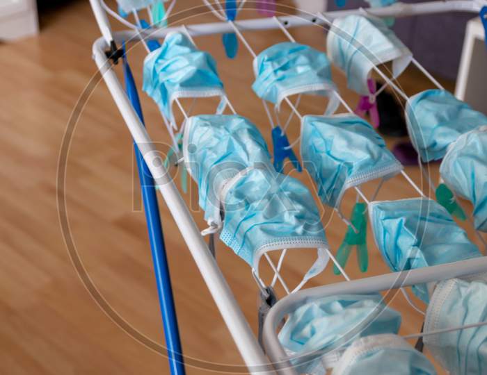 Image of Washed surgical masks hanging on a clothes drying rack after