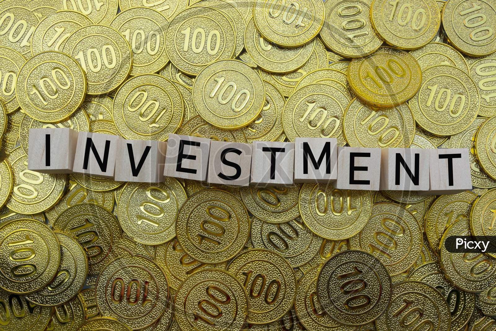 Investment Text On Wood Block With A Pile Of Coins