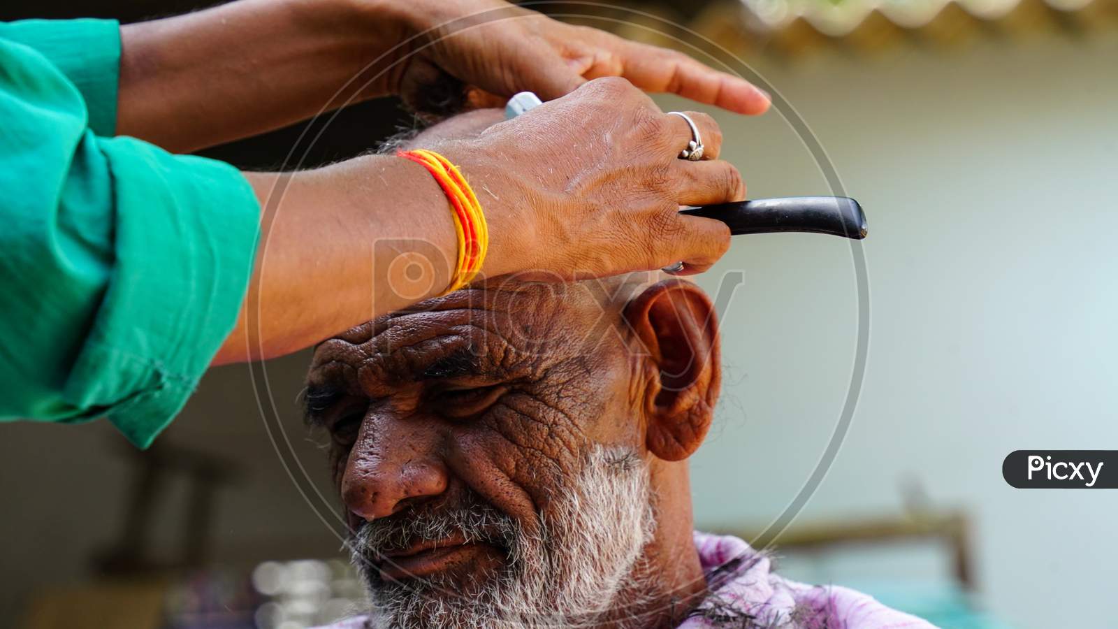 Indian Rural Shot, Traditional Barber Shaving Old Man In Village Of Rajasthan, India.