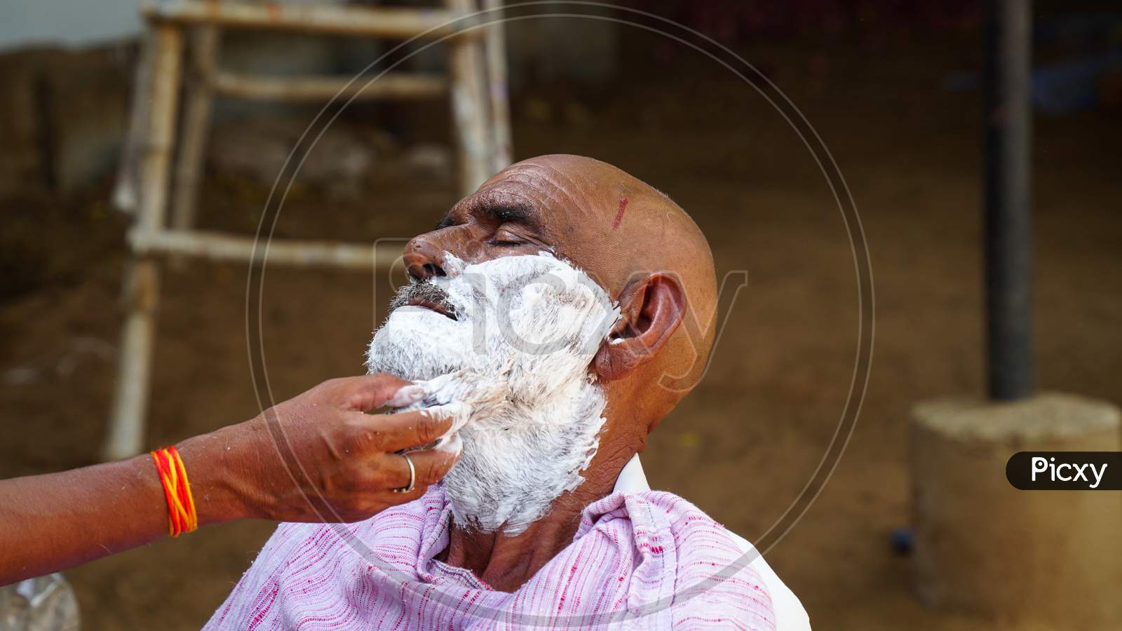 Indian Barber Working On The Village Streets In A Sunny Day