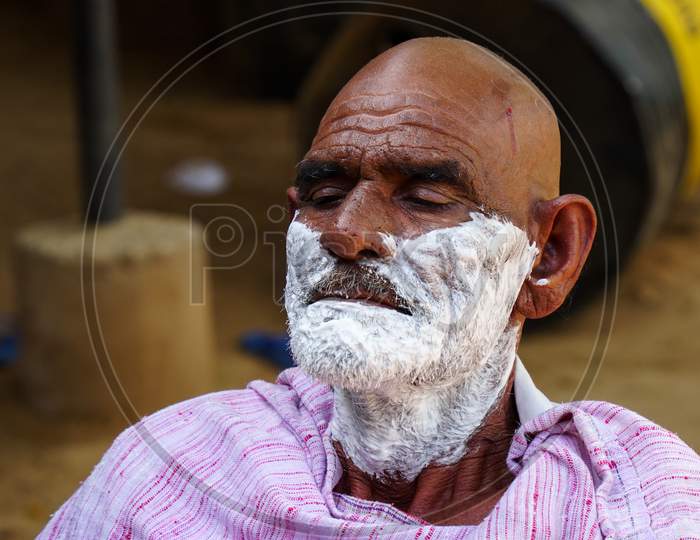 A Traditional Barber Is Shaving A Man In Village Of Sikar,India. Rural India Landscape.