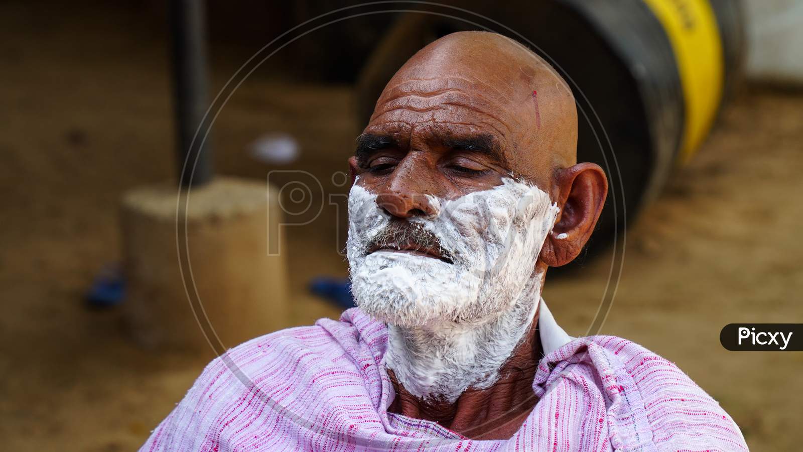 A Traditional Barber Is Shaving A Man In Village Of Sikar,India. Rural India Landscape.