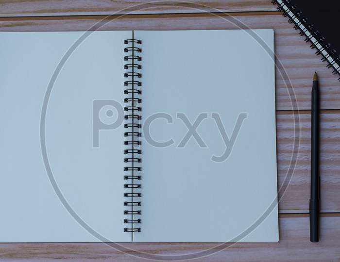 Notepad With Pen On Wooden Background