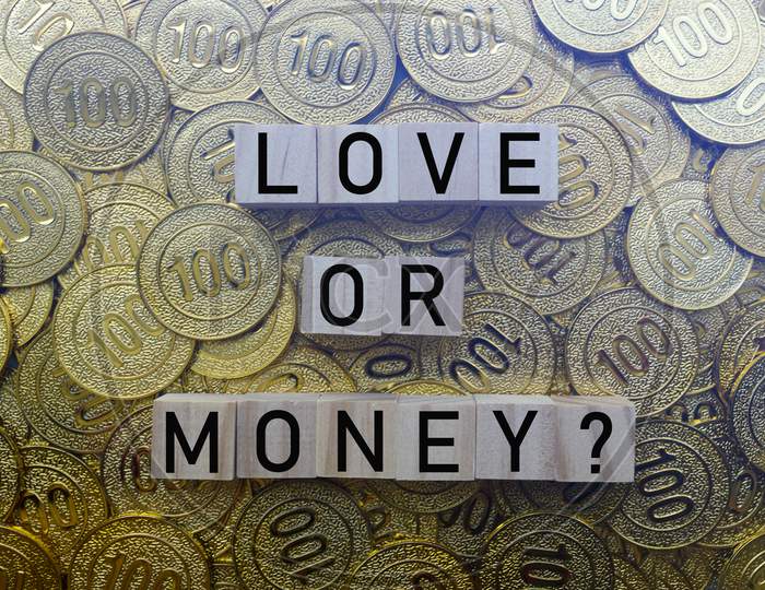 Love Or Money Text On Wood Block With A Pile Of Coins