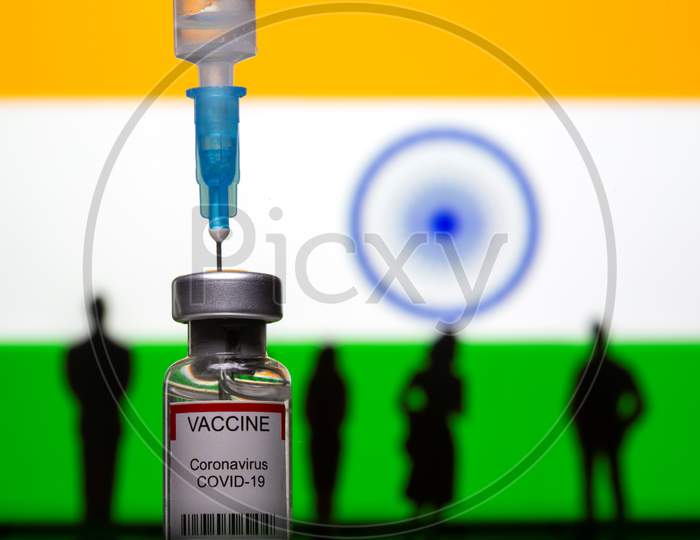 3D-Printed Small Toy Figurines, A Syringe And Vial Labelled "Coronavirus Disease (Covid-19) Vaccine" Are Seen In Front Of India Flag In This Illustration
