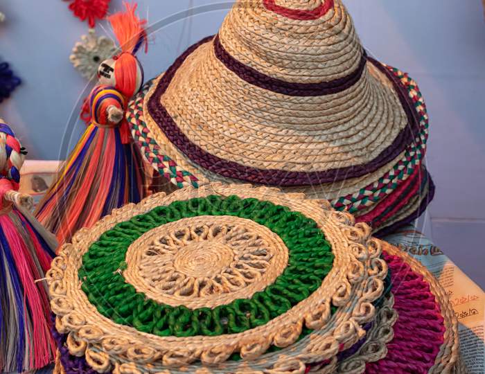 Beautiful Handmade Hats And Doormats Made By Jute Is Displayed In A Shop For Sale In Blurred Background. Indian Handicraft