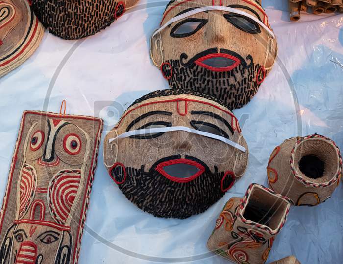 Beautiful Handmade Mask Made By Jute Is Displayed In A Shop For Sale In Blurred Background. Indian Handicraft