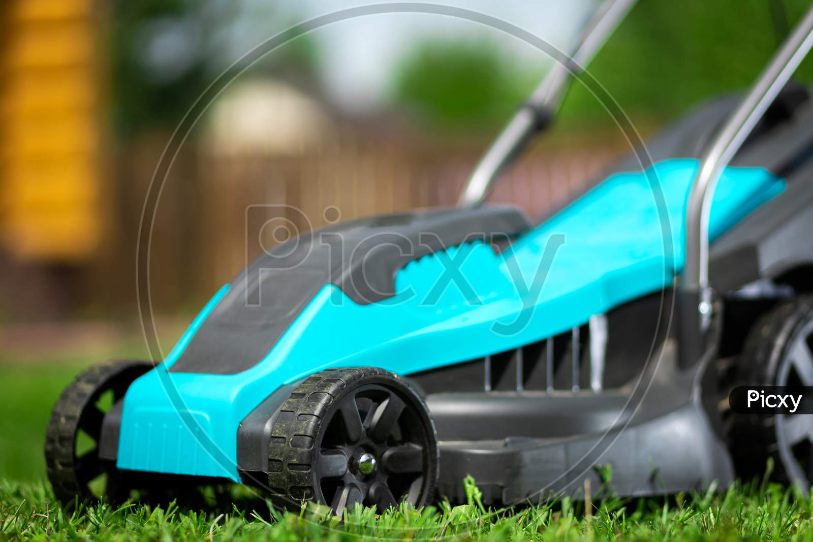 Close Up Of The  Electric Lawn Mower Mowing The Lawn. Pruning And Landscaping A Garden, Cutting Grass, Lawn, Paths