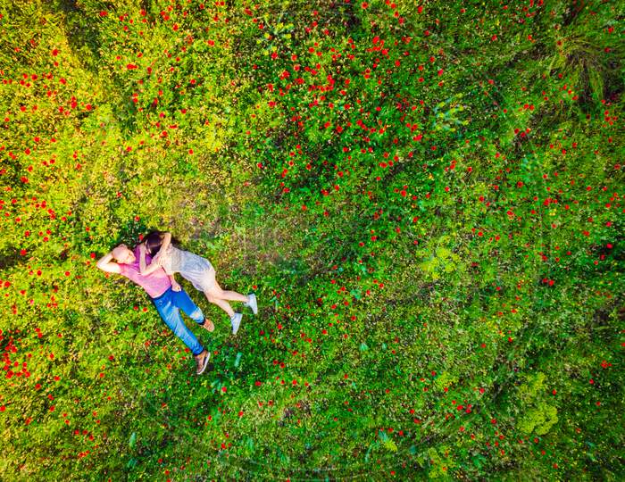 Happy Couple Together In Love Isolated Laying In Green Nature Field On Summer Day. Top View Copypaste Background