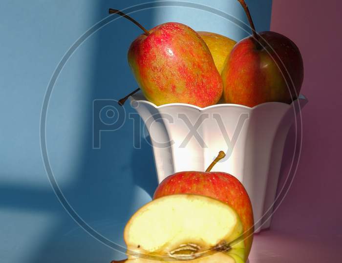Photo Of An Apple In A Container On A Pink And Blue Background