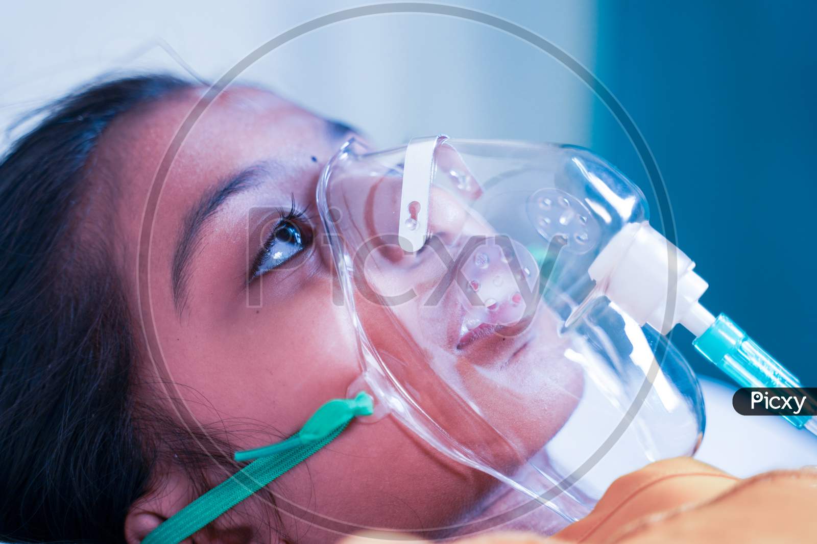 Close Up Shot Of Little Girl Kid Breathing On Ventilator Oxygen Mask At Hospital Due To Coronavirus Covid-19 Breath Shortness Or Dyspnea - Concept Of Children Healthcare And Medical During Pandemic.