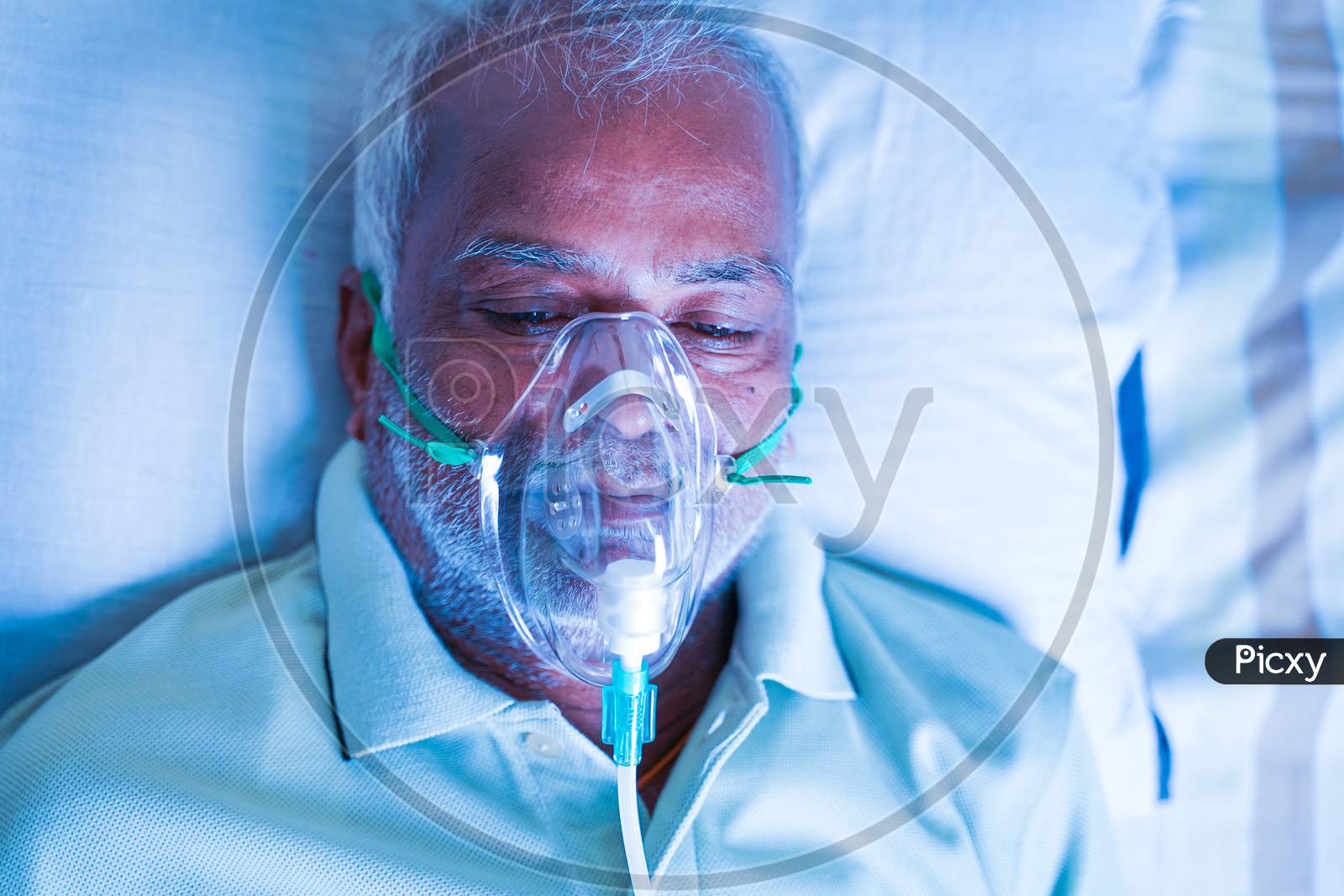 Close Up Top View Head Shot Of Old Breathing With Ventilator Oxygen Mask At Hospital Due To Coronavirus Covid-19 Breath Shortness Or Dyspnea