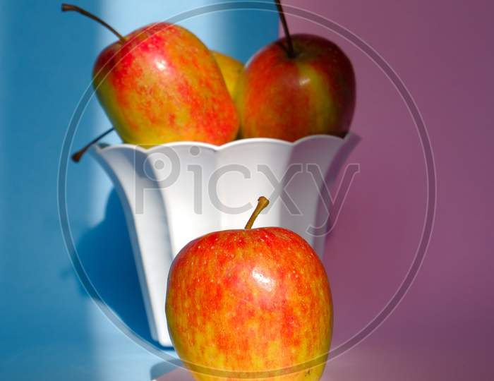 Photo Of An Apple In A Container On A Pink And Blue Background