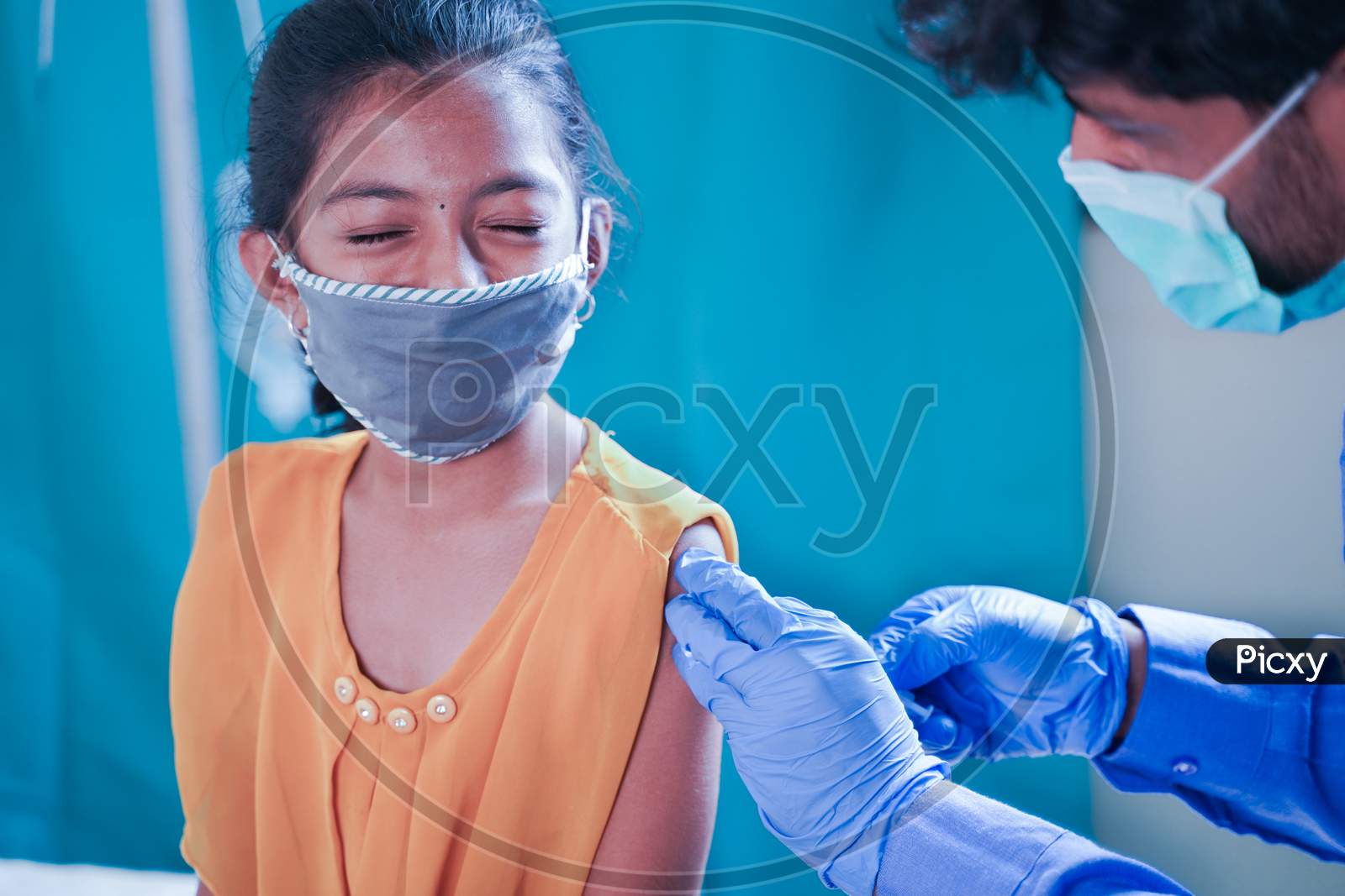 Concept Of Covid-19 Coronavirus Vaccination For Children - Young Girl Kid Getting Jab Or Vaccinated To Against Covid At Hospital