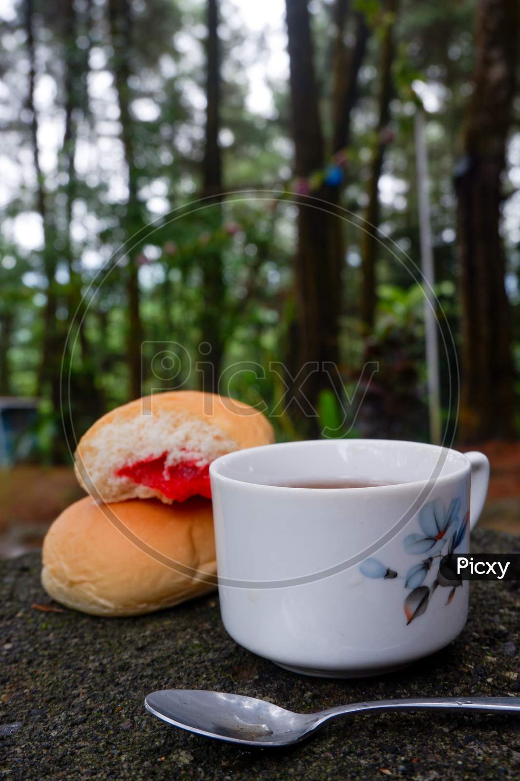 Photo Of Bread With Strawberry Jam With A Cup Of Tea. In A Photo In A Forest
