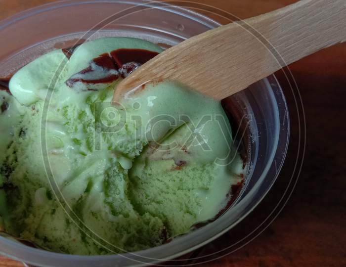 The Photo Is A Photo Of Avocado-Flavored Ice Cream In A Cup With A Black Background