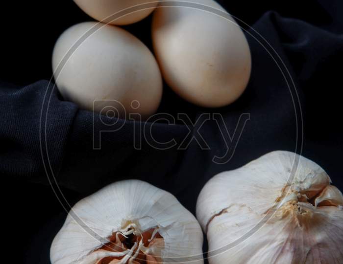 Egg And Garlic Photo On Black Background