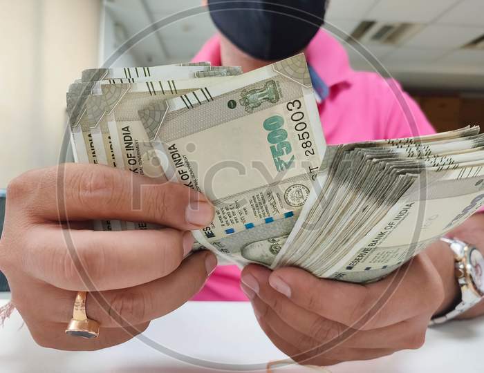 Man Counting Indian Rupee With Hand With Mask On Face.