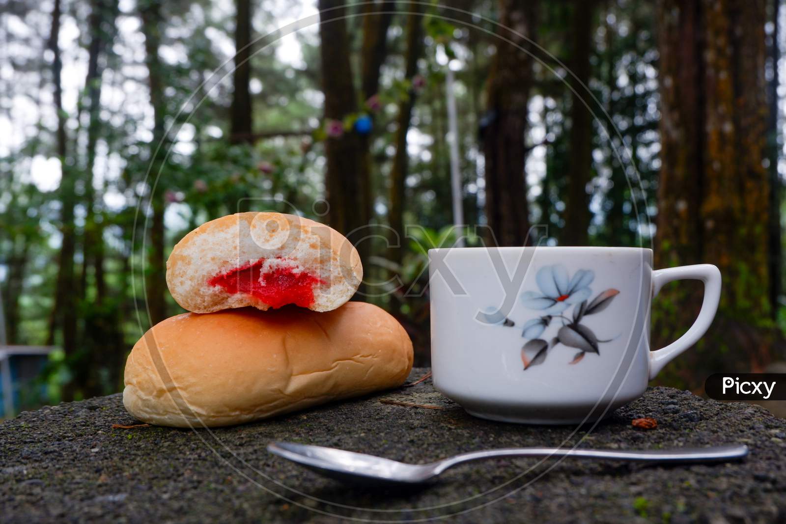 Photo Of Bread With Strawberry Jam With A Cup Of Tea. In A Photo In A Forest