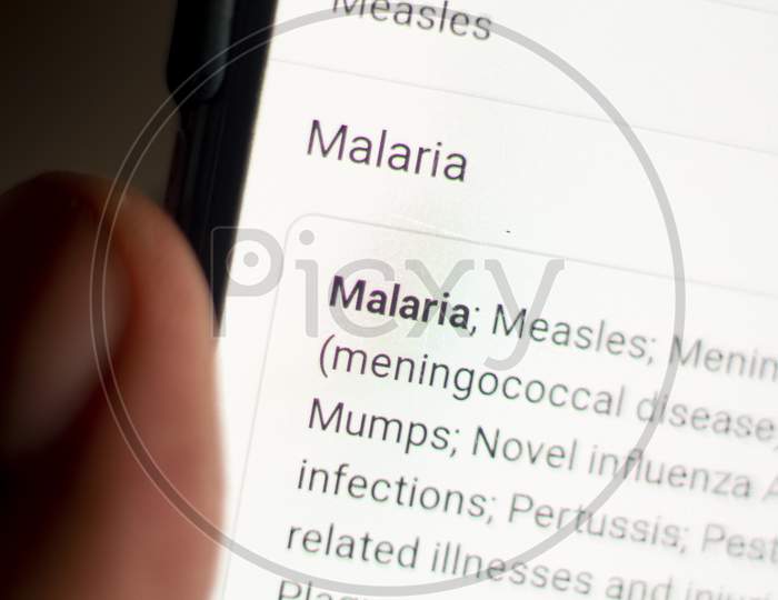 Malaria News On The Phone.Mobile Phone In Hands. Selective Focus And Chromatic Aberration Effects.