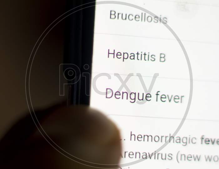 Dengue News On The Phone.Mobile Phone In Hands. Selective Focus And Chromatic Aberration Effects.